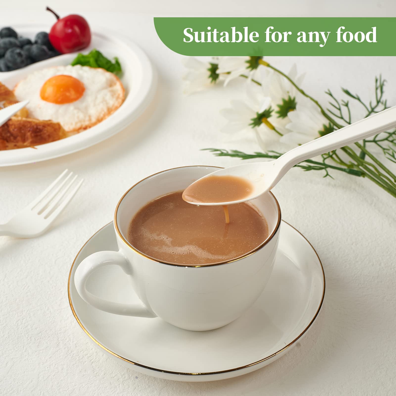 A white cup with a gold rim holds soup; a spoon lifts soup from the cup. A breakfast plate with fruit and a fried egg is nearby.