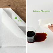 ECOLipak two-ply paper towels shown on a wooden surface, demonstrating their softness and absorbency next to spilled coffee.