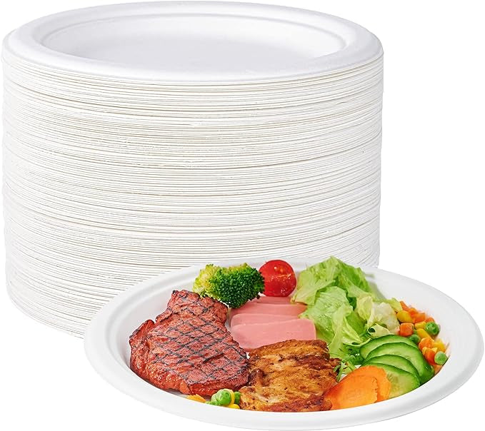 A stack of white disposable plates next to a plate featuring grilled steak, vegetables, and ham, ready for a meal.