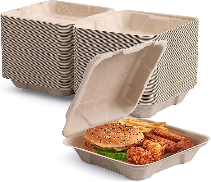 Stack of eco-friendly food containers beside an open box filled with a burger, fries, and chicken wings.