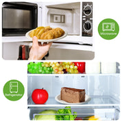 A hand holding a plate of fried dumplings from a microwave, alongside a refrigerator displaying fresh fruits and a chocolate cake.